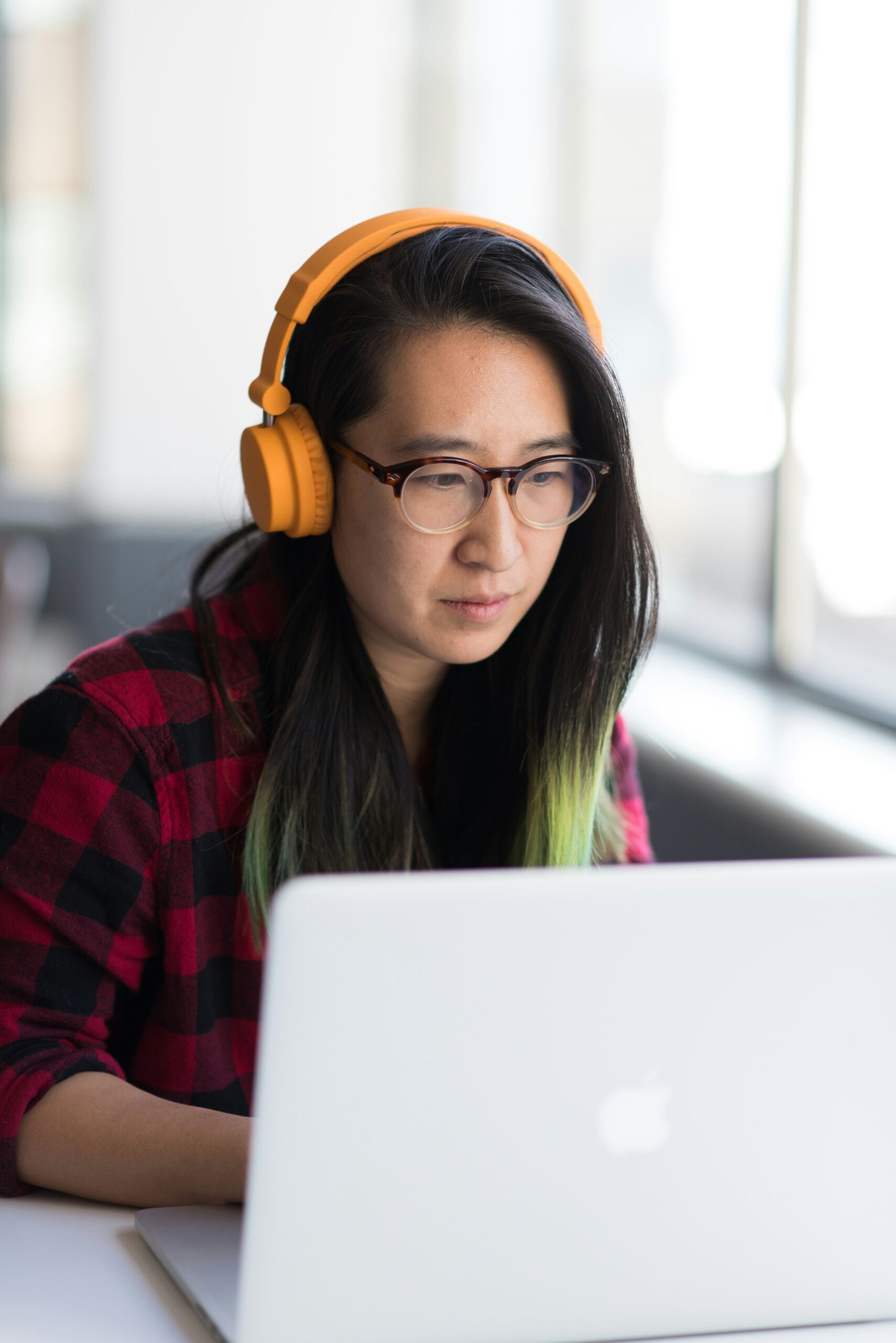 woman in headphones working at laptop