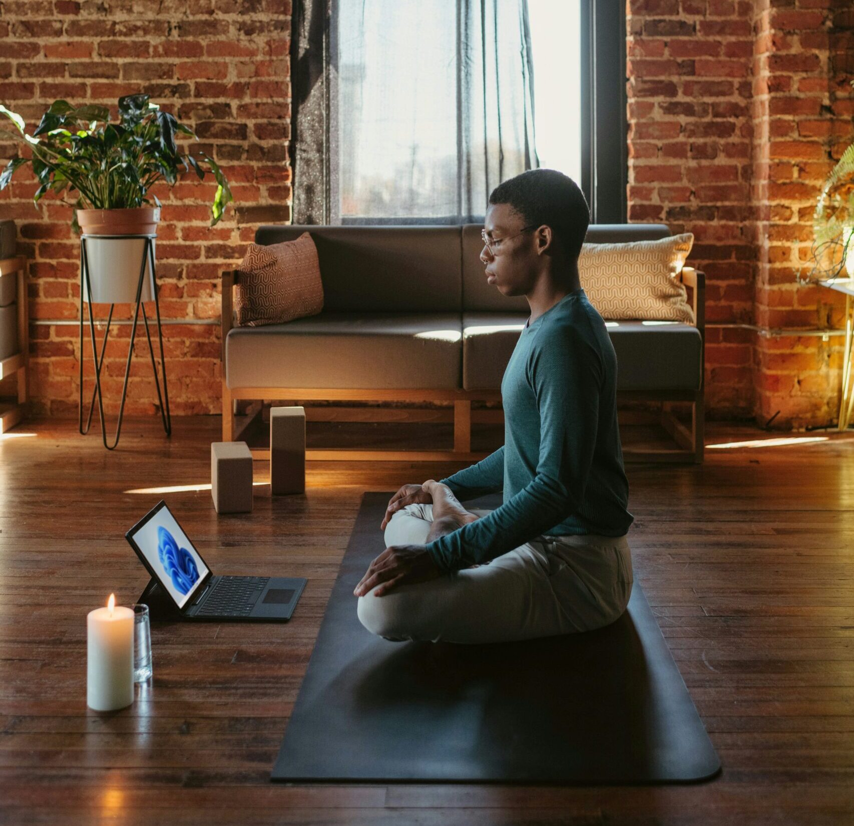 Man sitting cross legged on yoga mat in meditation