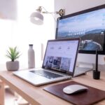Laptop and screen monitor with a mouse on a work table
